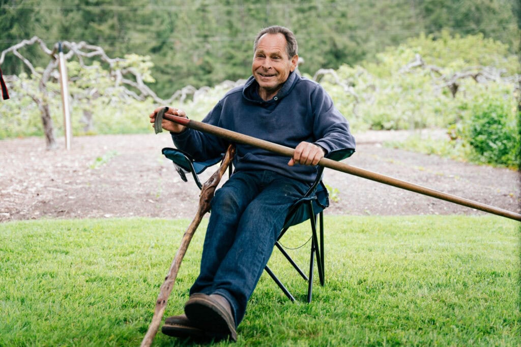 Gardener resting beside a vegetable garden after working with mulch and soil