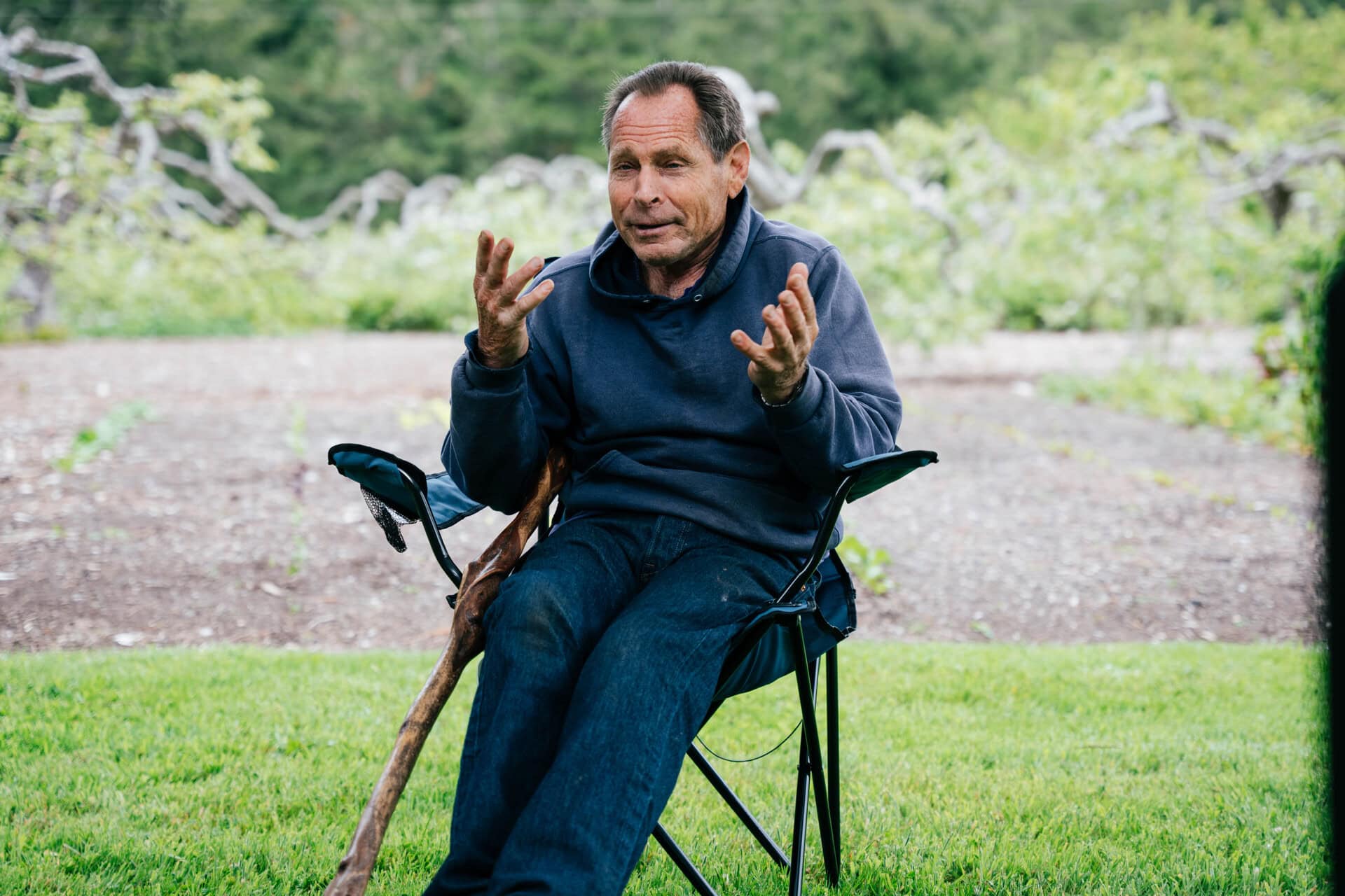 Paul Gautschi explaining the Back to Eden gardening method while seated in a garden orchard.